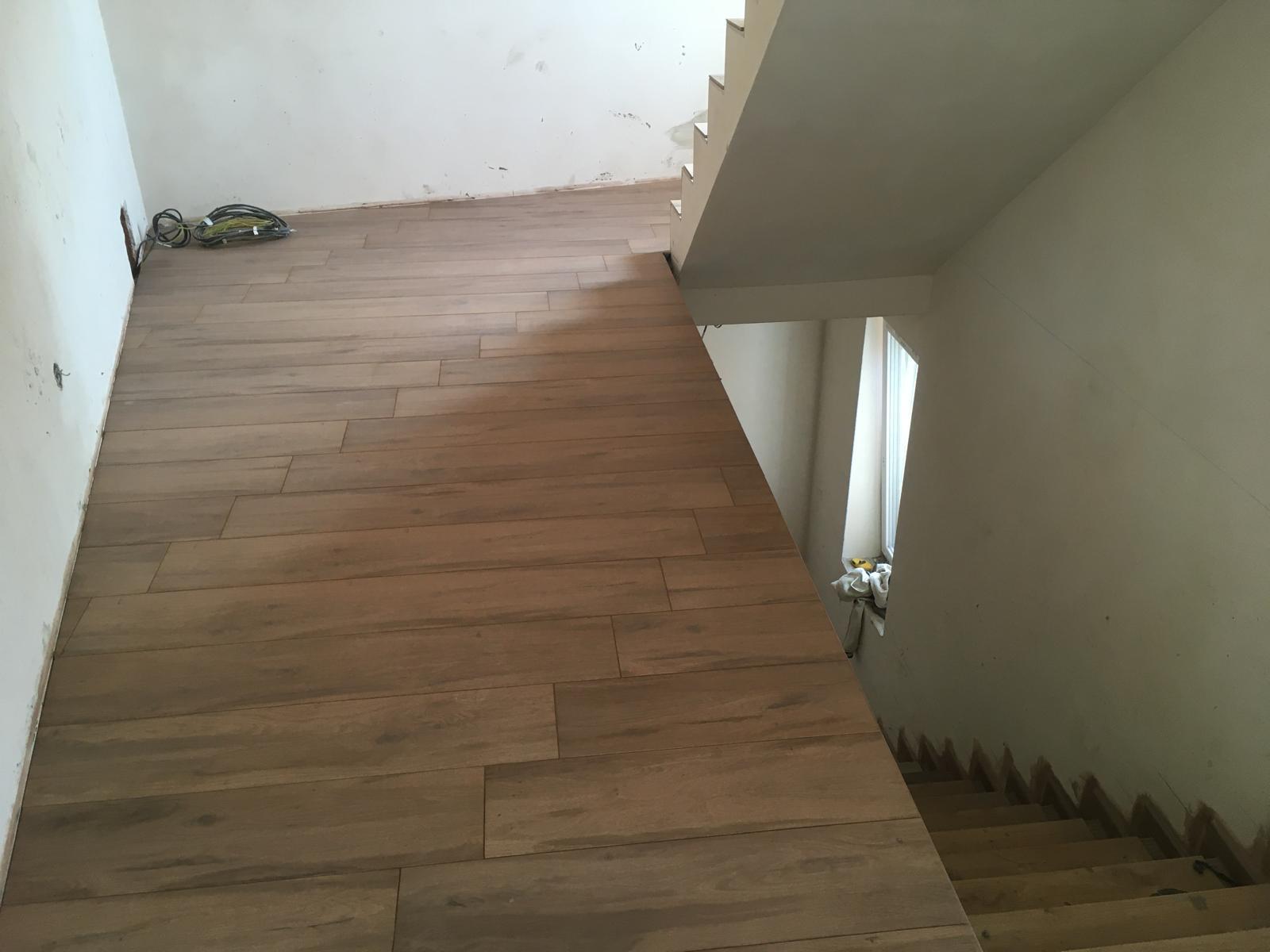 Treppenbereich mit durchgehendem Fliesenbelag in Holzoptik